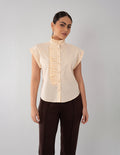 Blusa beige con diseño plisado en cuello y botones
