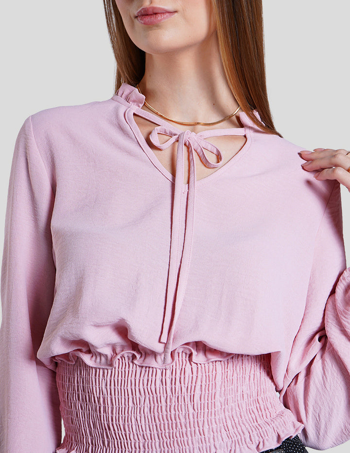 Blusa rosa de manga larga y detalle de smock en la cintura