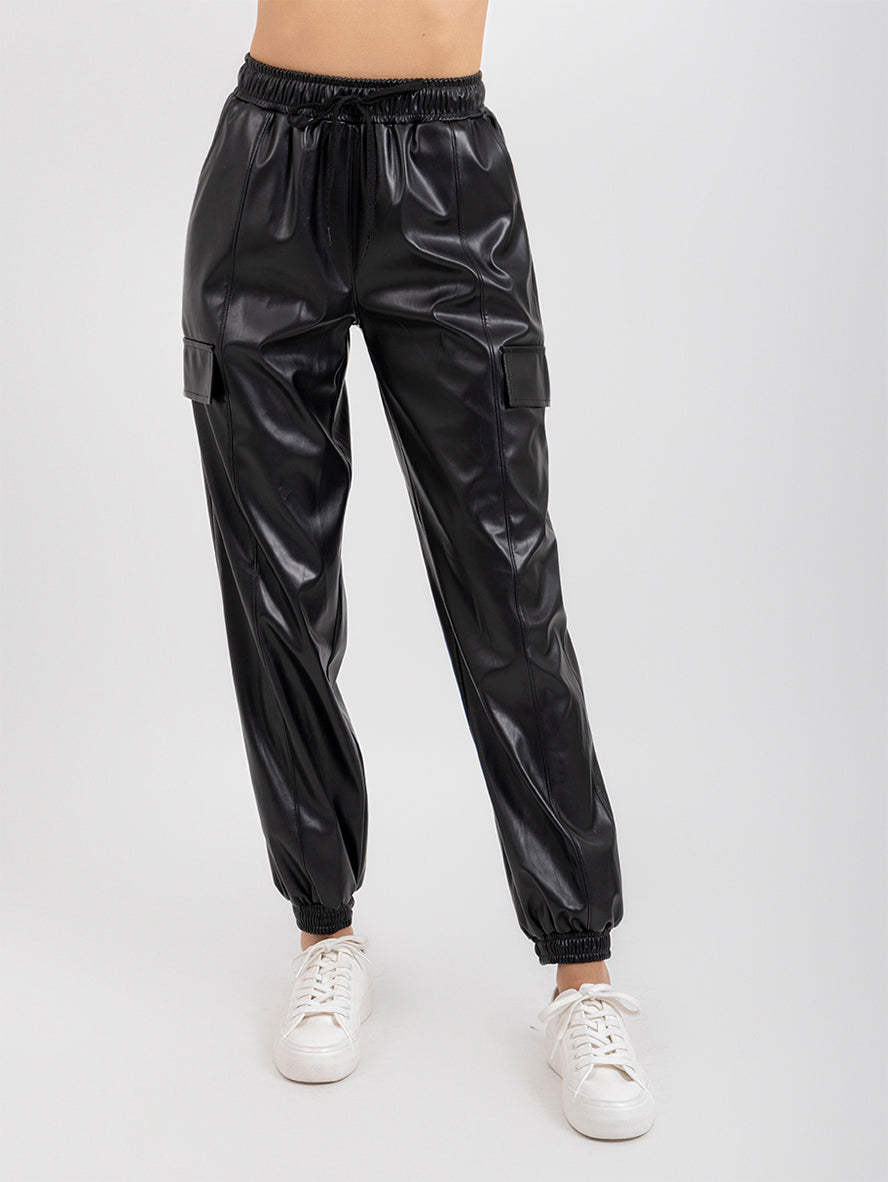 Pantalón negro  tipo jogger con bolsas en tela vinipiel y jareta en cintura