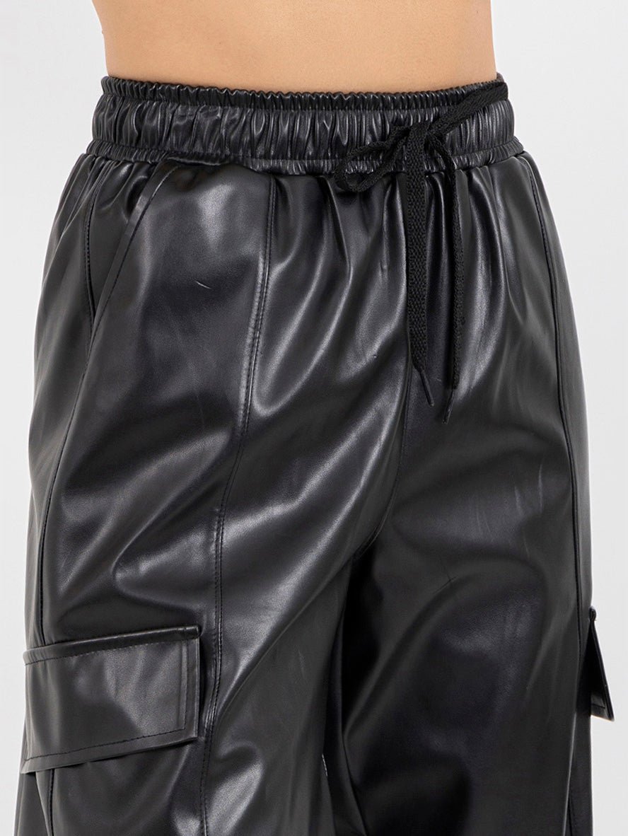 Pantalón negro  tipo jogger con bolsas en tela vinipiel y jareta en cintura
