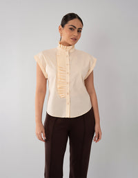 Blusa beige con diseño plisado en cuello y botones